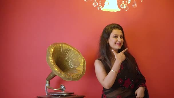 Seorang Wanita India Dengan Saree Hitam Berdiri Samping Gramofon Tersenyum — Stok Video
