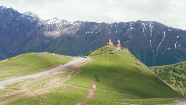 Gergeti Üçlemeci Katedrali Nin Arka Planında Devasa Dağ Sıraları Olan — Stok video