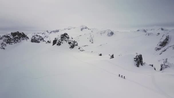 Воздушные Накладные Лыжники Пересекают Быстро Заснеженный Горный Ландшафт — стоковое видео