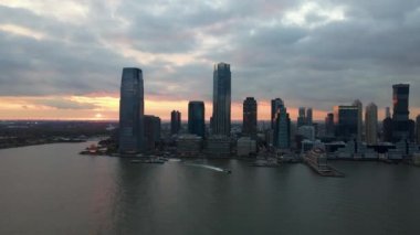 New York 'ta dramatik gün batımında Jersey şehir manzarasına doğru insansız hava aracı görüntüsü.