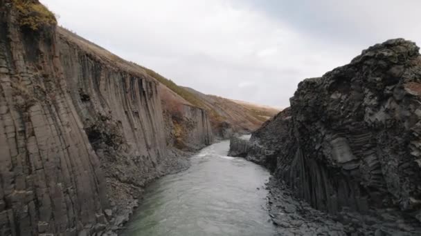 无人驾驶飞机飞越冰河上方冰岛狭窄的Studlagil峡谷 — 图库视频影像