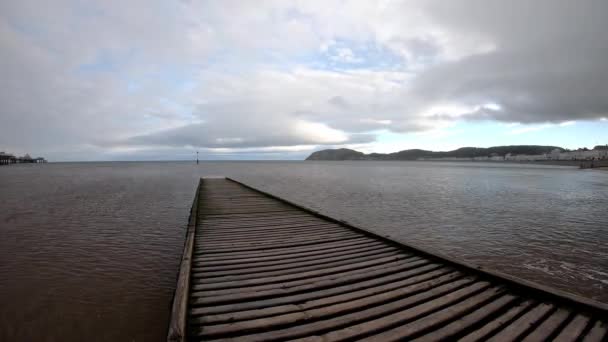空の木製の桟橋の下の時間経過波パルスは 曇りの海の風景につながる散歩 — ストック動画