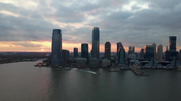 ニューヨークの劇的な日没でジャージーの街並みへの空中ドローンの眺め — ストック動画