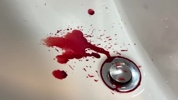 血が沈み込むのが遅い ゆっくりとした動きで血の滴 水槽の穴に血のしみが 人間の怪我で事故 浴室での出血 — ストック動画