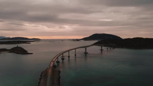 ドローンがノルウェーのソマロイ橋を飛ぶように美しいピンクの空の夕暮れシーン — ストック動画