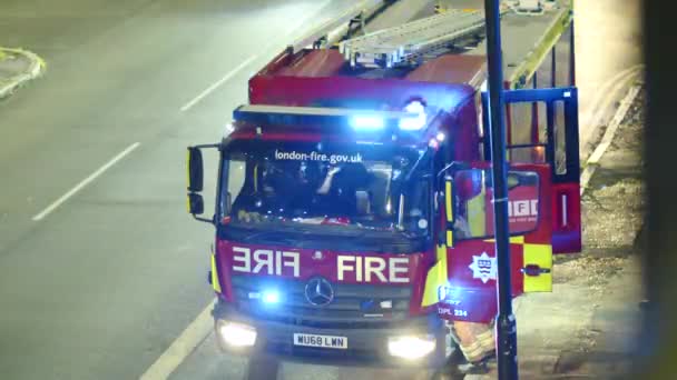 Egy Tűzoltó Beszáll Egy Tűzoltóautóba Éjjel Londonban Angliában — Stock videók