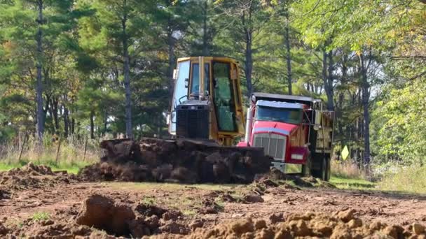 今年秋天 John Deere 560H Lgp推土机在农村地区的一个建筑工地上推土 背景是一辆垃圾车 建筑和经济增长的概念 — 图库视频影像