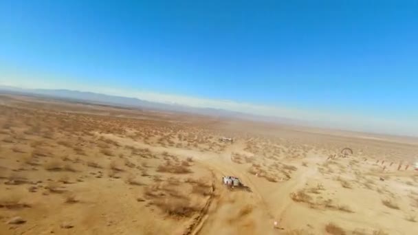 ほこりの多いダートトラックに沿って4輪駆動トラックスピードアップモハーヴェ砂漠ラリーやオフロードレース 航空一人称視点 — ストック動画