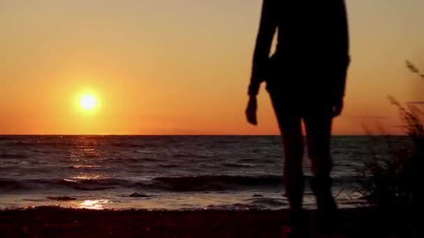 在海滩上走进日落的女孩 太阳进入大海 温暖的黄金时间阳光 夏天外出远足 探索拉脱维亚 — 图库视频影像