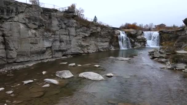 カナダのアルバータ州南部では Lundbreckに接近しているSlo Mo航空ショットが落下します 曇り空の秋の朝にリモート観光地の4K映画の映像 峡谷を大量の水が流れ落ちる — ストック動画