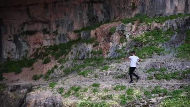 Wysoki Młody Arab Rzuca Piłkę Zwolnionym Tempie Skalistym Środowisku Jaskiniowym — Wideo stockowe