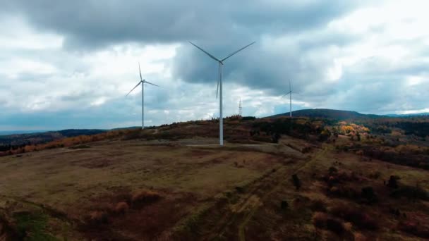 山の美しい丘の上にエネルギー生産のために回転風車の空中ビュー 風力発電機は 持続可能な開発のためにクリーンな再生可能エネルギーを生み出す ドローン映像 — ストック動画