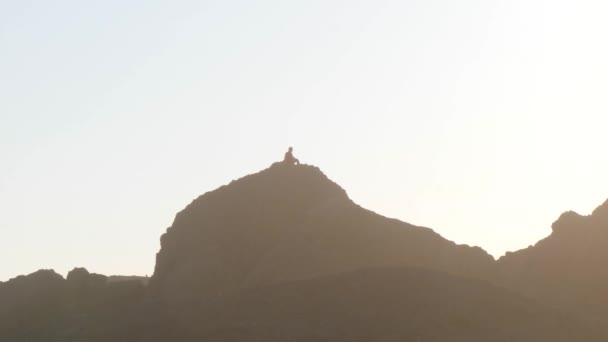 Ein Mann Sitzt Auf Einem Großen Felsen Der Küste Von — Stockvideo