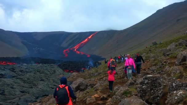 アイスランドのレイキャヴィークにあるモルテン ラヴァ川を見るためにファグラダルフィヨール火山で旅行する観光客 — ストック動画