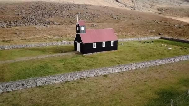 ブダキルクジャ固体赤屋根墓地緑と火山地形を持つ黒い教会トラッキングパン — ストック動画