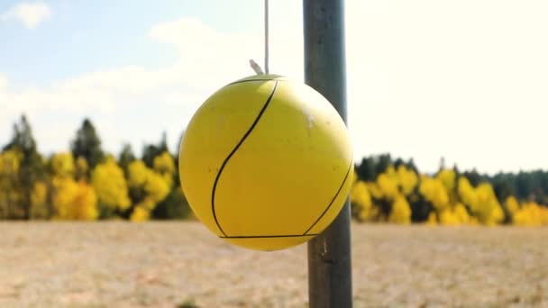在水泡背景下 用秋叶绳悬吊在固定金属杆上的黄色球体 关门了 — 图库视频影像