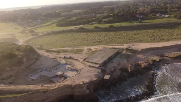 Aerial Wysokiej Kąt Strzał Skaliste Wybrzeże Piaszczystej Plaży Docierając Fale — Wideo stockowe