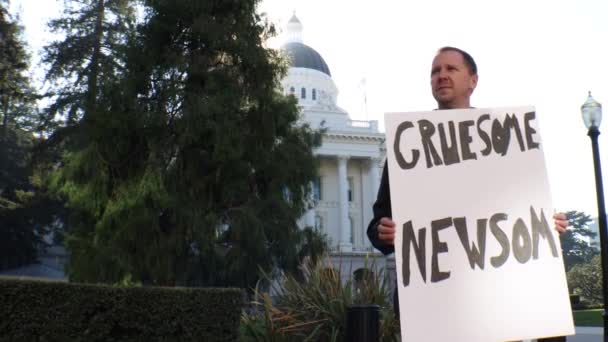 Mężczyzna Polityczne Protestujący Makabryczny Newsom Znak Suwak Dolly Śledzenie Strzał — Wideo stockowe