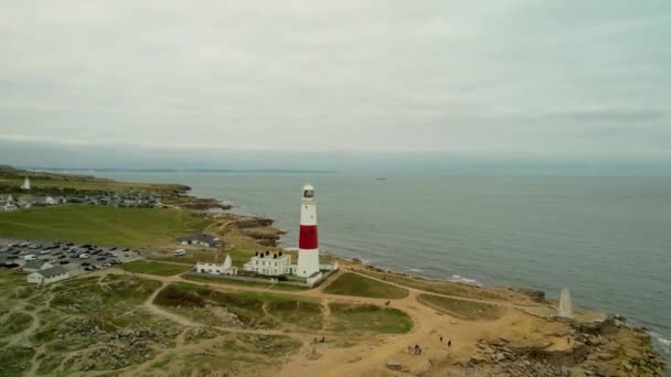 イギリスの砂浜の海岸線に近い美しい灯台 空中飛行ショットに向かって — ストック動画
