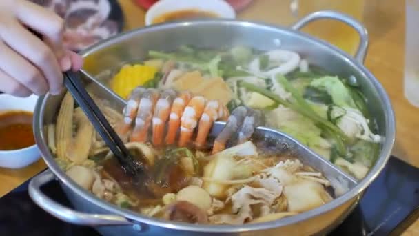 野菜と肉をたっぷり使った鍋しゃぶしゃぶに豚スライス肉を入れながら4K動画ハメ 日本のアジア料理のコンセプト — ストック動画