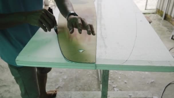 Een Man Markeert Snijkant Voor Een Surfplank Een Indoor Workshop — Stockvideo