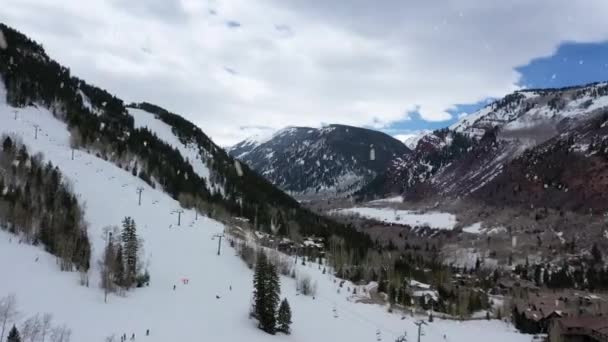 降雪中のケーブルカートとスキー複合体 空中ドローン回転ビュー — ストック動画