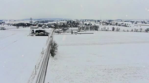 雪嵐の間の広いオープン農村農場フィールドの航空 冬の田園風景 — ストック動画