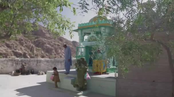 ヒルサイドスモールヒンドゥー教寺院を出る家族 NagarparkarのKarhoonjar Hillsで — ストック動画