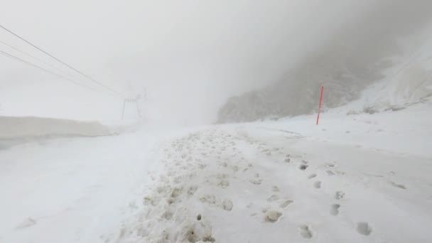 非常に急な雪の山を歩いて山のPovショット 雲の中を歩いているのでとても霧が多い — ストック動画