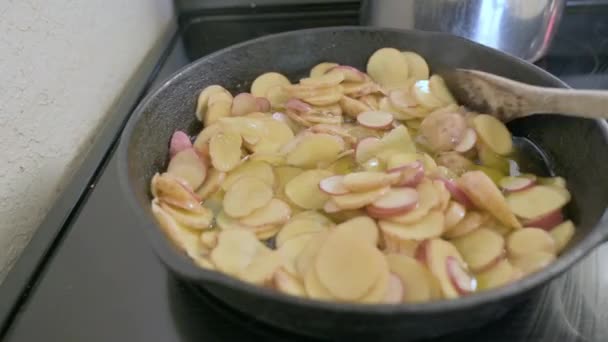 鋳鉄製の鍋に油で揚げたおいしいジャガイモ 木製のスプーンで攪拌 — ストック動画