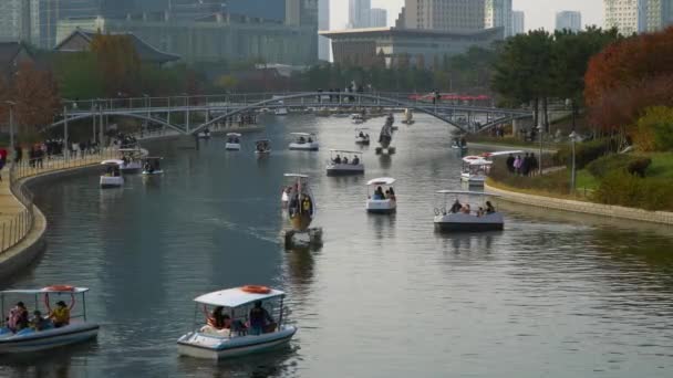 仁川松島中央公園 秋の季節に湖の上の小さなボートで多くの人々が旅行 — ストック動画