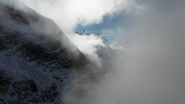 スイスのスイスアルプスの雲の中を雪の上を飛んでいくドローン映像 — ストック動画