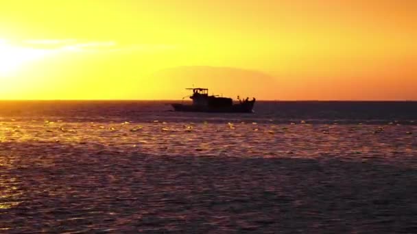 Silhouet Van Boot Passeren Door Oceaanwater Tijdens Heldere Oranje Gouden — Stockvideo