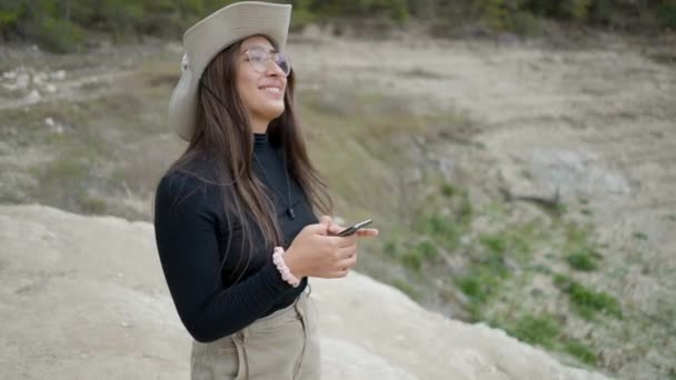 Chica Sombrero Utiliza Teléfono Sonríe Cámara Paisaje Pedregoso Cerca — Vídeo de stock