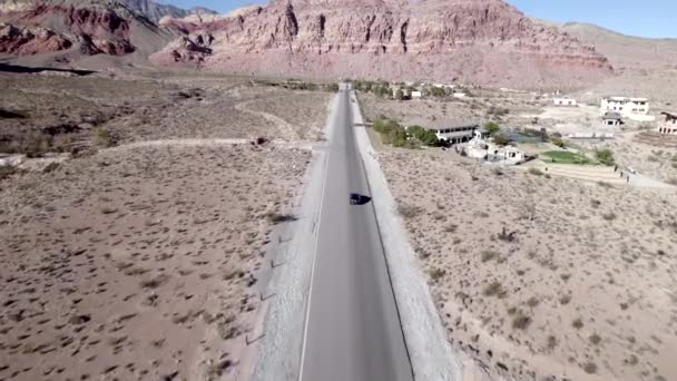 レッドロックキャニオンハイウェイ ラスベガス ネバダ州に沿って車の運転のドローン追跡ショット — ストック動画