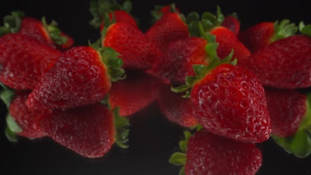 Μακροσκοπική Άποψη Περνώντας Πάνω Από Κόκκινες Φράουλες Ανακλαστικό Μαύρο Γυαλί — Αρχείο Βίντεο