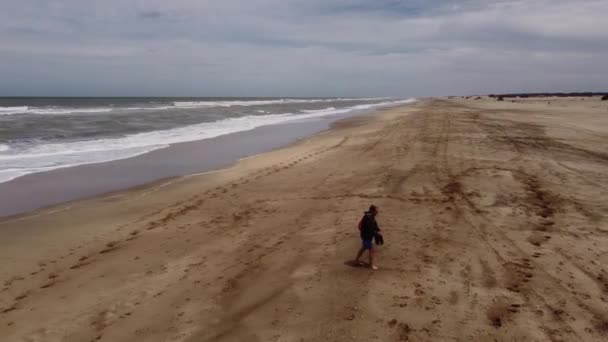 Aerial Tracking Shot Man Walking Sandy Beach Waves Ocean Background — Stock Video