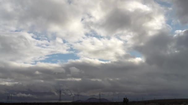 莫哈韦沙漠 高山和输电塔上空的云彩景观 广角时滞 — 图库视频影像