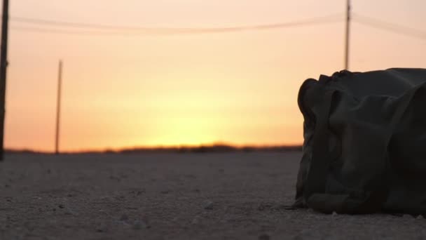 Primer Plano Bolsa Del Ejército Suelo Desrt Atardecer — Vídeos de Stock