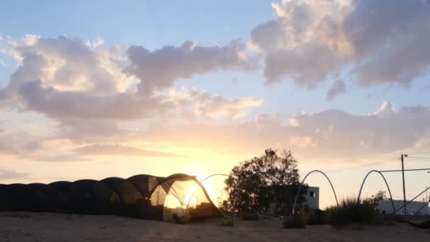 在沙质沙漠地带的黑色温室的背景下 夕阳西下 — 图库视频影像
