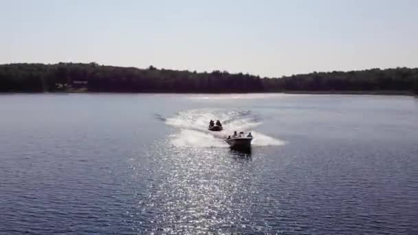 黄金の時間の間に湖のボート牽引管の追跡ショット — ストック動画