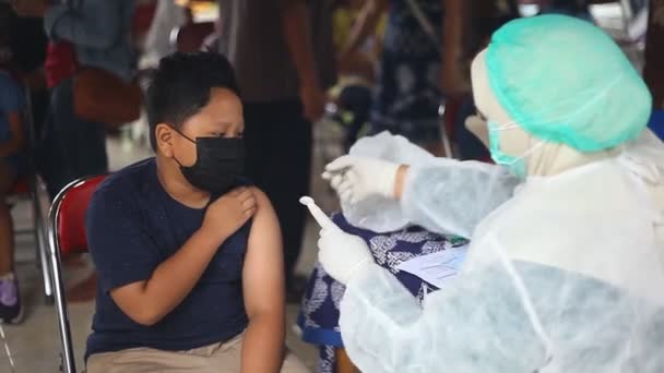 Yogyakarta, Indonésie - 20. prosince 2021: základní školák statečně dostává vakcínu covid-19