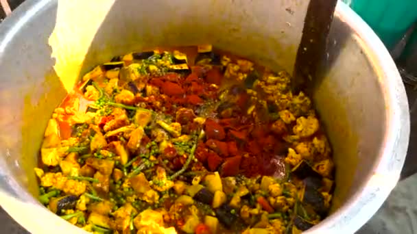 インドの祭りで100人用の大きな鍋でおいしい混合野菜カレーを調理する — ストック動画