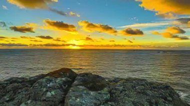 Günbatımında, Guernsey Adası 'nda, Normandiya sahillerinde sihirli renkli gökyüzü. Hiperlapse