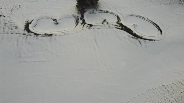 ゴルフ場で雪に覆われたバンカーとフェアウェイの空中ショットを上げる — ストック動画