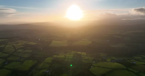 ラウンドウッド ウィックロー アイルランド 2021年12月遠くに金色の冬の夕日と夕方の農地に向かって徐々に降下します — ストック動画