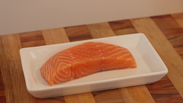 新鮮な鮭の切り身の周りに弧運動 白いセラミックプレート上の生の魚の切り身 調理シーン — ストック動画