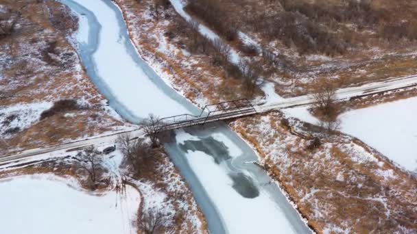 Wysoka Antena Starego Żelaznego Mostu Obejmującego Zamarzniętą Pokrytą Śniegiem Rzekę — Wideo stockowe