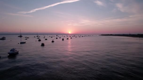 海岸線に停泊しているボートのドローンビュー 夕焼け曇天 — ストック動画