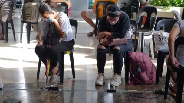 필리핀 타이푼 라이에 도시의 전기가 파괴된 쇼핑센터에서 마스크로 스마트폰을 충전하는 — 비디오